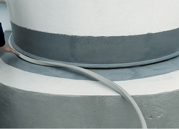Insert a backer rod into the void between the tank and the concrete base