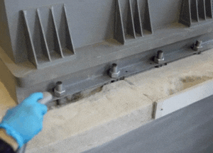 Clean the damaged concrete base using a brush or vacuum to remove all loose material 